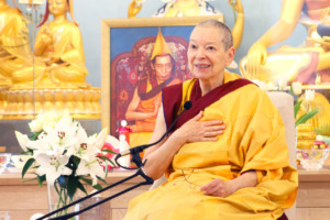 buddhistische Nonne sitzend vor einem buddhistischen Schrein