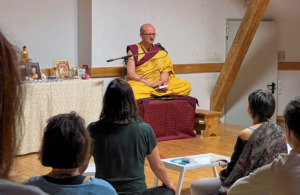 Mönch beim Meditieren mit Gruppe